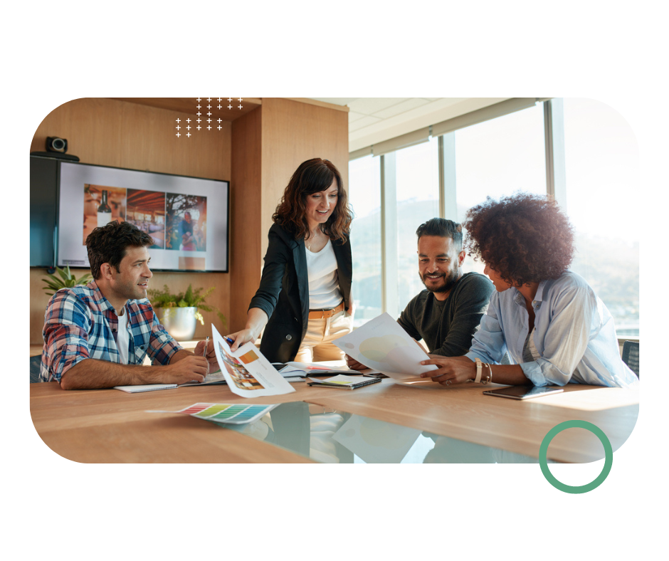 a group of people holding papers and working together around a table