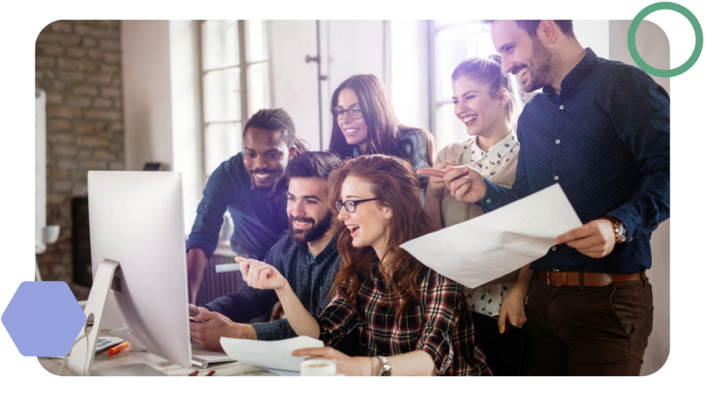 a smiling marketing team huddled around a computer screen